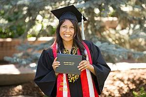 Smiling 研究生 with her diploma on graduation day